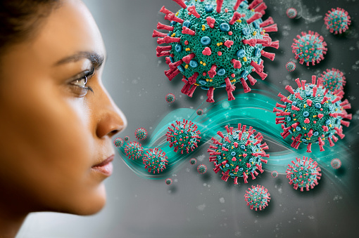 Woman inhaling corona virus COVID-19.
The image is a scientific interpretation of the virus with all relevant details : Spike Glycoproteins, Hemagglutinin-esterase, E- and M-Proteins and Envelope.